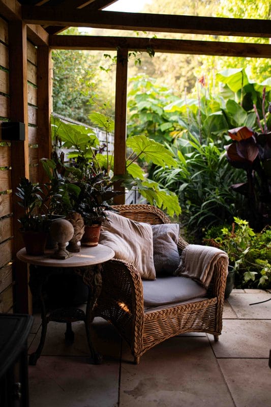 gardening garden design landscaping horticulture Surrey West Sussex outdoor living seating summer parties bbq's barbecue patio pergola coffee table armchair wicker potted plants jungle tropical planting outdoor kitchen